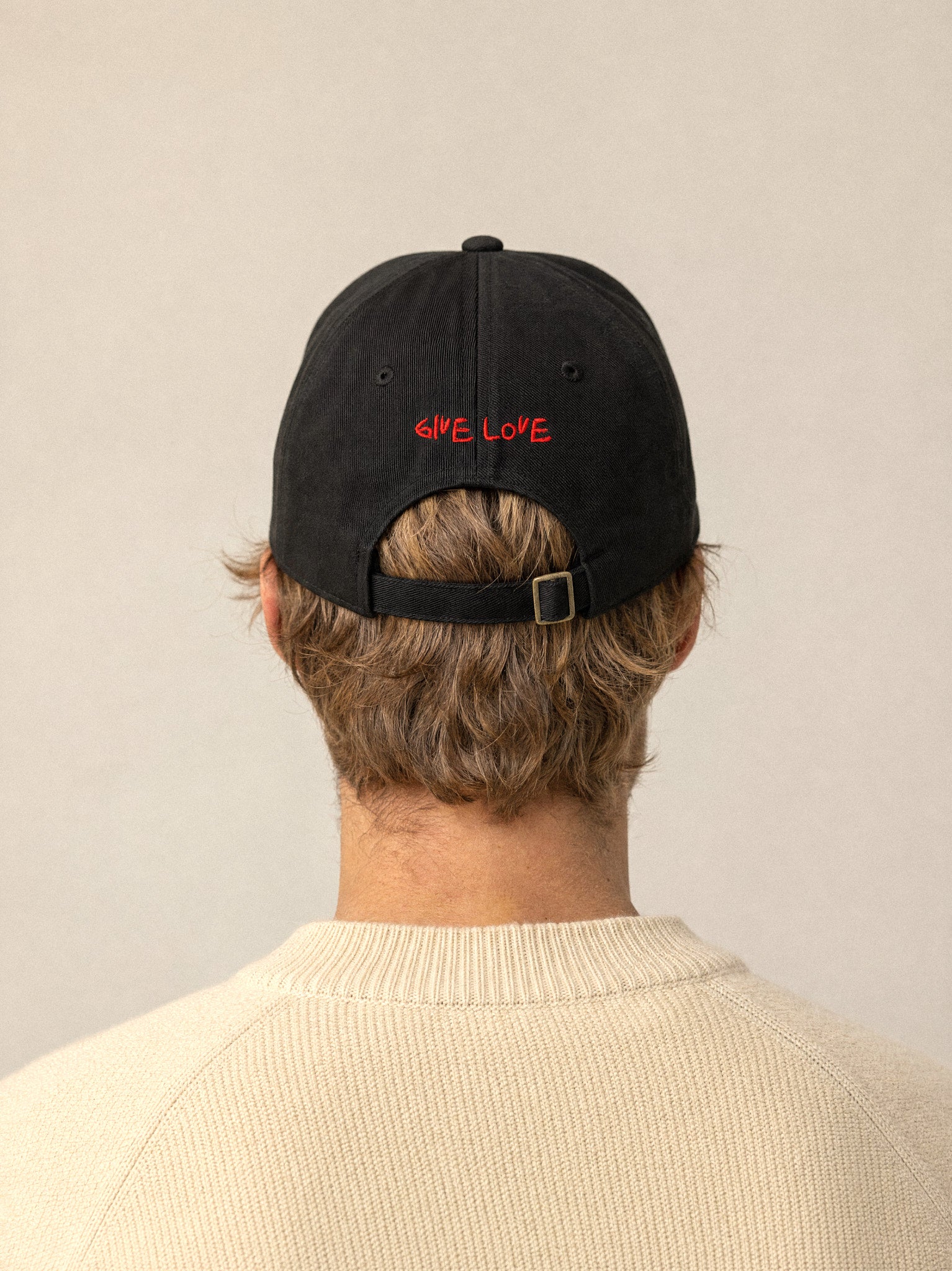 cap charity heart arrow black back give love blonde man