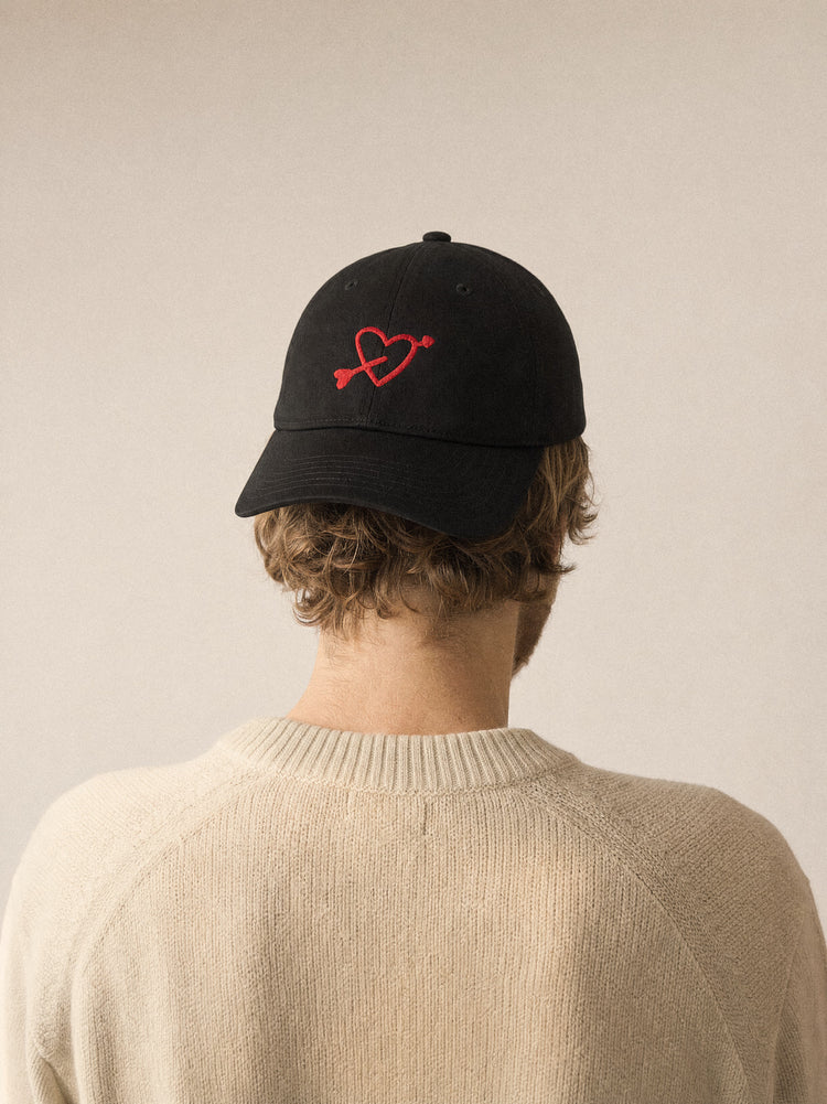 cap charity heart arrow black front view blonde man